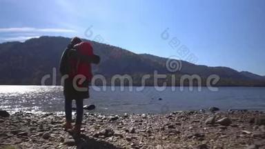 山湖。 堕落。 那个带着红色背包的旅行者的女人在湖岸上<strong>花钱</strong>。